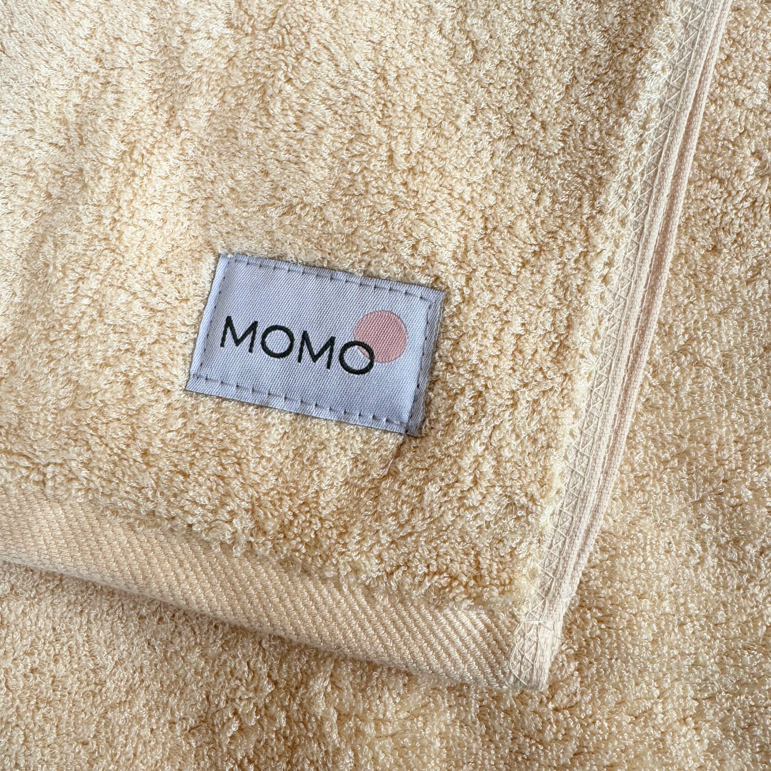 Beige bamboo towel with Momo logo – soft, absorbent and sustainable