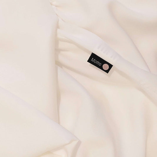 Detalle de la etiqueta en sábana de bambú blanco perla – ropa de cama suave, transpirable y sostenible