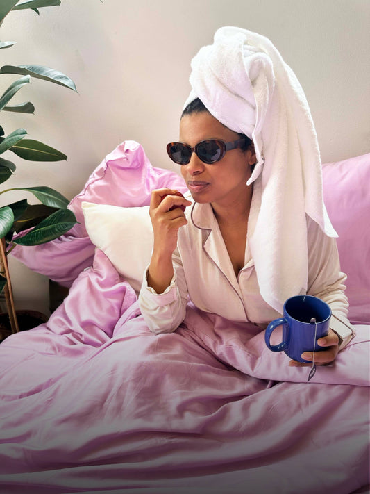 Toallas en la cama, mujer elegante tomando té