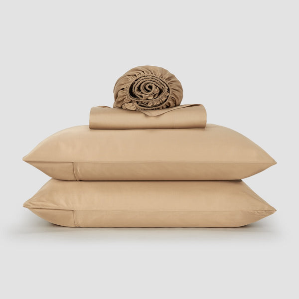 Mujer en cama con sábanas y almohadas de bambú rosa – ropa de cama suave, transpirable y sostenible