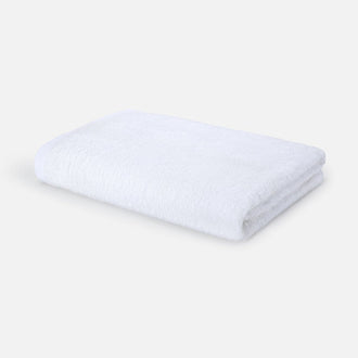 White folded bath towel on neutral background, Wabi-sabi design by Momo Cotton, 70x140cm