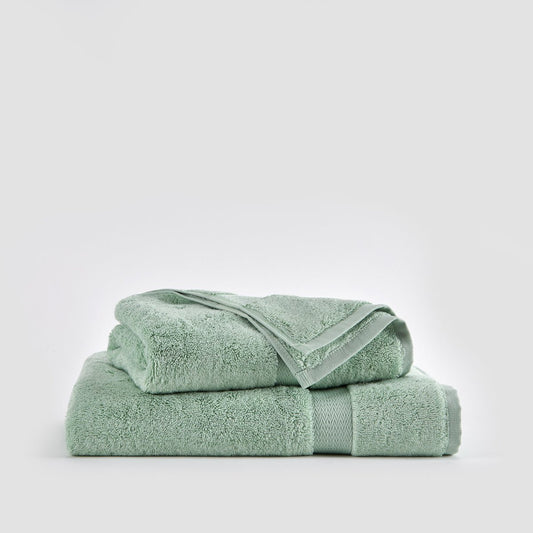 Juego de toallas de bambú Alba en verde claro apiladas, incluye toalla de cara, mano y baño