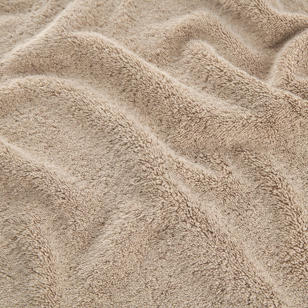 Beige bamboo towel set showing soft, textured fabric detail of face, hand and bath towels