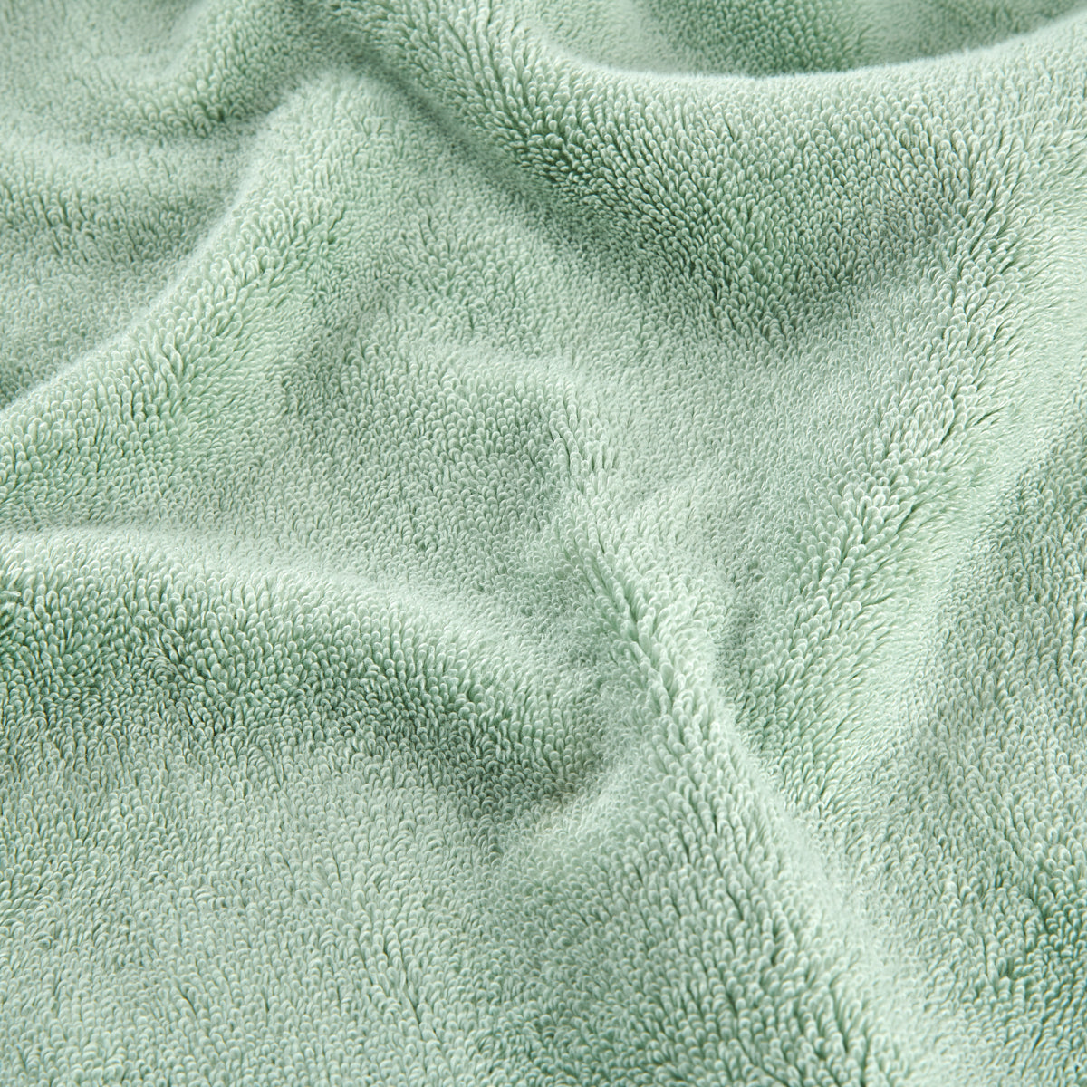 Juego de toallas de bambú verde mostrando detalle de textura suave del tejido en vista de cerca