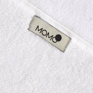 Etiqueta de marca MOMO en primer plano del tejido de toalla de bambú blanco