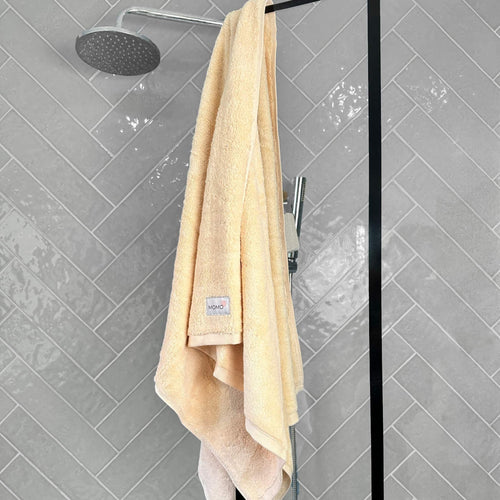 Beige bamboo bath towel on grey background – soft, absorbent and sustainable