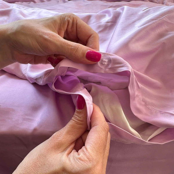 Primer plano de botones de funda nórdica de bambú rosa abrochándose – tela de alta calidad, suave y sostenible
